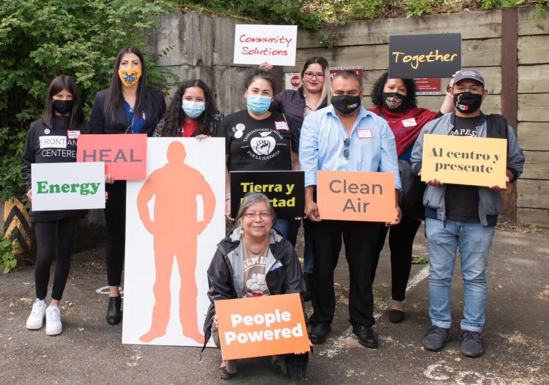 Participants holding signs at HEAL Act bill signing, including clean air
